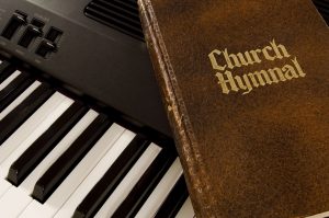 Hymnal And Keyboard a church hymnal sitting on top of a keyboard.